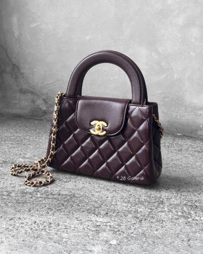 Chanel Dark Brown Mini Kelly Shopping Tote in shiny calfskin leather with gold hardware. A chic, structured design that blends elegance with everyday style.
